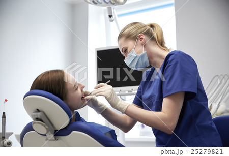 female dentist checking patient girl teeth 25279821