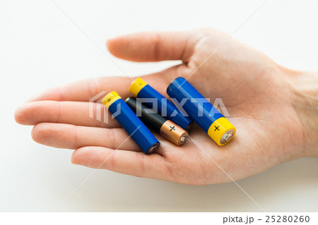 close up of hands holding alkaline batteries heap 25280260