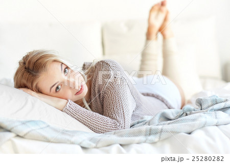 happy young woman lying in bed at home happy young woman lying in bed at home 25280282