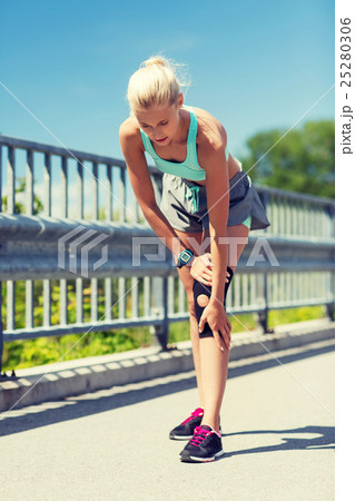 young woman with injured knee or leg outdoors 25280306