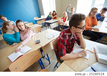 students gossiping behind classmate back at school 25280528