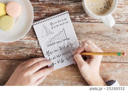 close up of hands writing mathematical equation 25280552