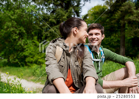 smiling couple with backpacks in nature 25280553