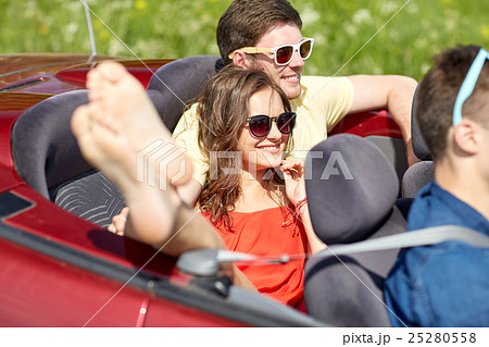 happy friends driving in cabriolet car outdoors 25280558
