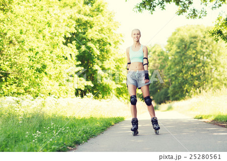 happy young woman in rollerblades riding outdoors 25280561