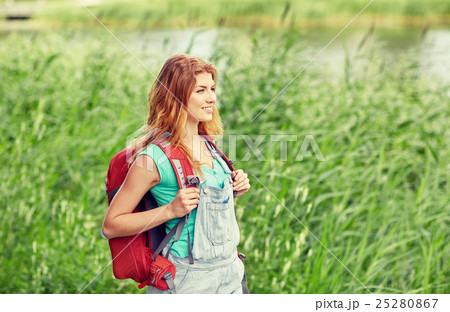 smiling young woman with backpack hiking in woods smiling young woman with backpack hiking in woods 25280867