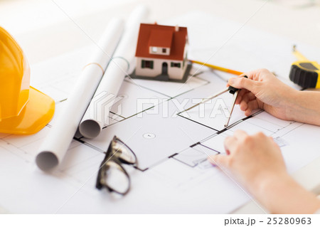 close up of hands with compass measuring blueprint 25280963