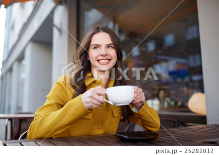 happy woman drinking cocoa at city street cafe happy woman drinking cocoa at city street cafe 25281012