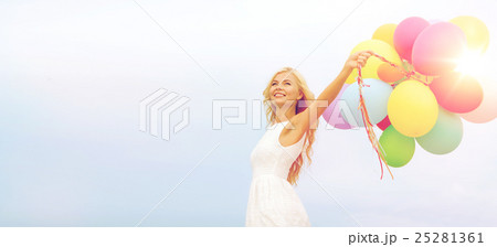 smiling woman with colorful balloons outside smiling woman with colorful balloons outside 25281361