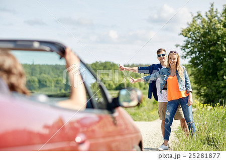 couple hitchhiking and stopping car on countryside 25281877