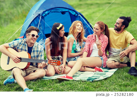 happy friends with drinks and guitar at camping 25282180