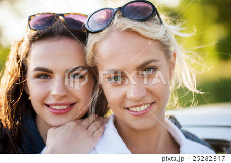 happy young women or teenage girls outdoors 25282347