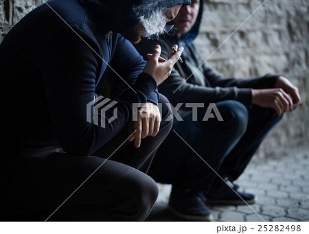 close up of young men smoking cigarettes 25282498