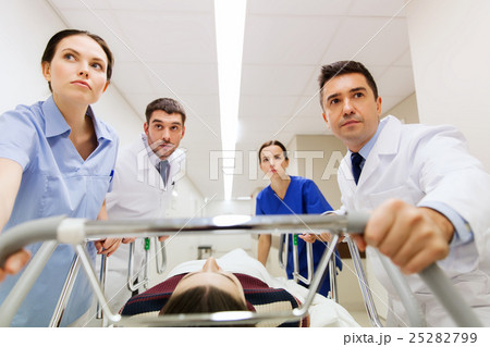 medics with woman on hospital gurney at emergency 25282799