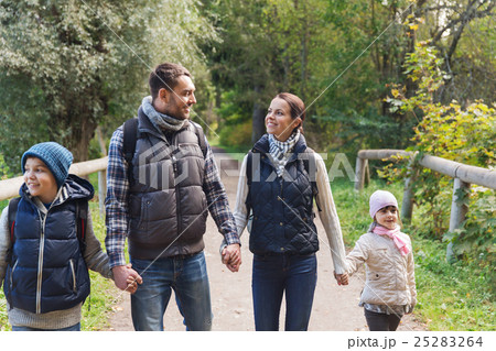 happy family with backpacks hiking in woods 25283264