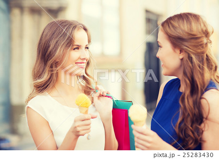 woman with shopping bags and ice cream in city 25283430