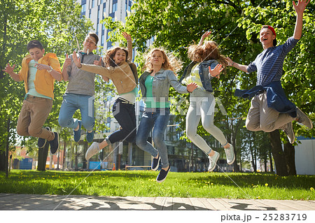 happy teenage students or friends jumping outdoors 25283719