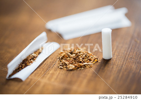 close up of marijuana or tobacco cigarette paper 25284910