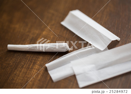 close up of marijuana joint and cigarette paper close up of marijuana joint and cigarette paper 25284972