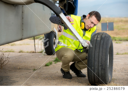 Checking aircraft's tire Checking aircraft's tire 25286079