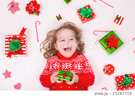 Little girl opening Christmas presents 25287719