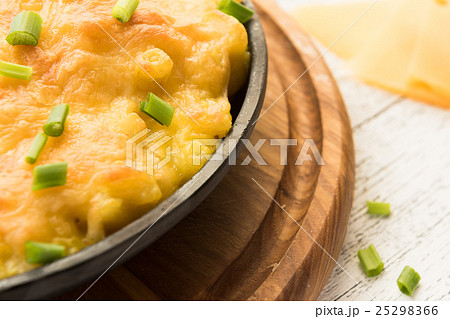 Baked cheesy pasta on the wooden background Baked cheesy pasta on the wooden background 25298366
