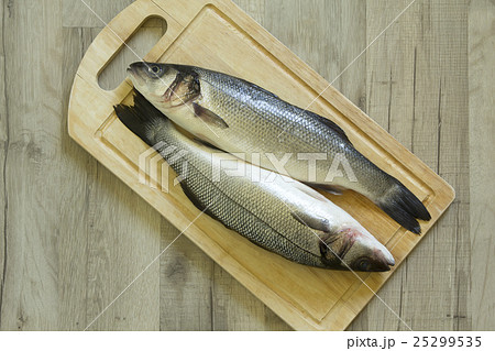 Whole seabass on a wooden board Whole seabass on a wooden board 25299535