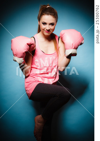 Female boxer wearing big fun pink gloves playing sports Female boxer wearing big fun pink gloves playing sports 25300762