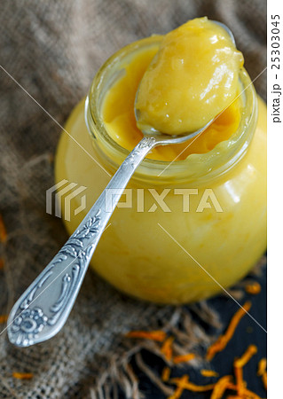 Jar with lemon custard and a teaspoon. 25303045
