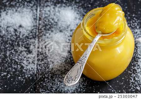 Lemon custard in a teaspoon and glass jar. Lemon custard in a teaspoon and glass jar. 25303047