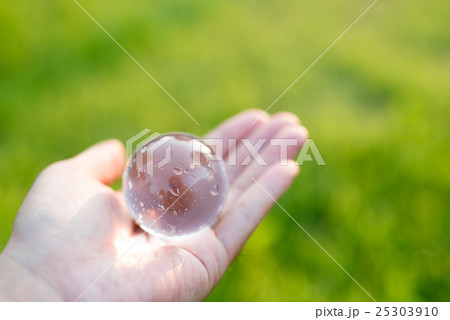 綺麗な芝生を背に手の上にある水晶 ガラス玉 環境 エコイメージ 綺麗な芝生を背に手の上にある水晶 ガラス玉 環境 エコイメージ 25303910