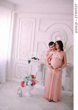 Family waiting for baby's birth. A pregnant woman and her husband wearing white clothing 25305537