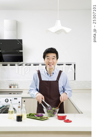 Middleaged Asian Man Making Salad in Kitchen 25307101