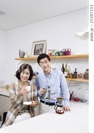 Middleaged Asian Couple Having Coffee in Kitchen 25307153