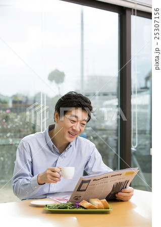 Middleaged Asian Man Reading Newspaper and Having Coffee at Home in the Morning Middleaged Asian Man Reading Newspaper and Having Coffee at Home in the Morning 25307156