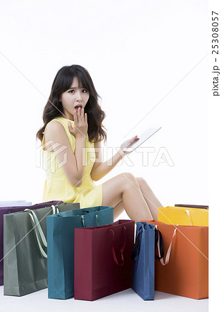 A young woman carrying a bunch of shopping bags A young woman carrying a bunch of shopping bags 25308057