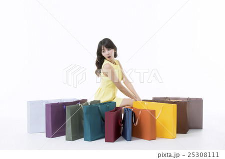 A young woman carrying a bunch of shopping bags 25308111