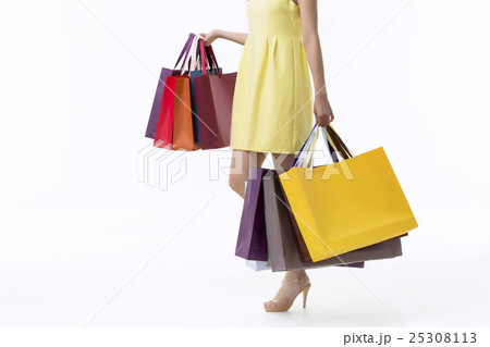 A young woman carrying a bunch of shopping bags A young woman carrying a bunch of shopping bags 25308113