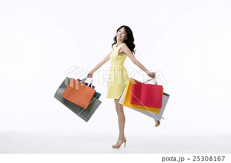 A young woman carrying a bunch of shopping bags A young woman carrying a bunch of shopping bags 25308167
