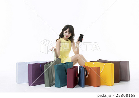 A young woman carrying a bunch of shopping bags 25308168