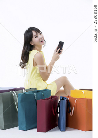 A young woman carrying a bunch of shopping bags 25308169