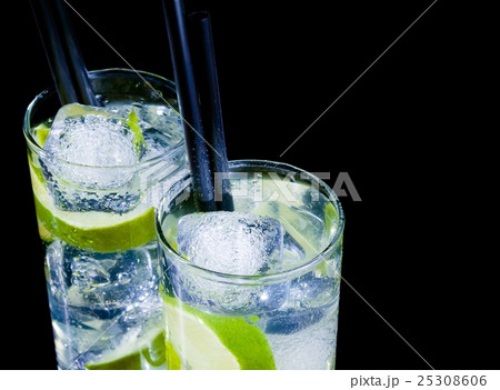 glasses with cocktail and ice with lime slice on black background with space for text glasses with cocktail and ice with lime slice on black background with space for text 25308606