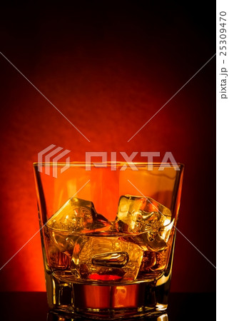 glass of whiskey on black table with reflection, red tint atmosphere glass of whiskey on black table with reflection, red tint atmosphere 25309470