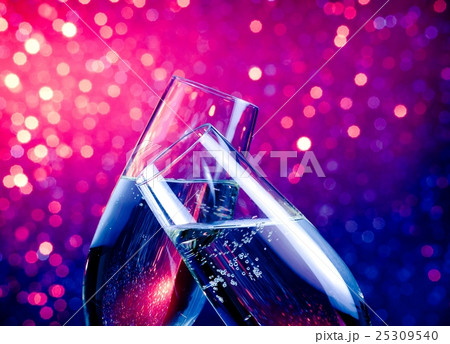 champagne flutes with gold bubbles on blue and violet tint light bokeh background champagne flutes with gold bubbles on blue and violet tint light bokeh background 25309540