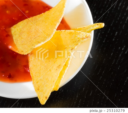 delicious crisp corn nachos with spicy hot tomato sauce as a snack or appetizer in a white disc delicious crisp corn nachos with spicy hot tomato sauce as a snack or appetizer in a white disc 25310279