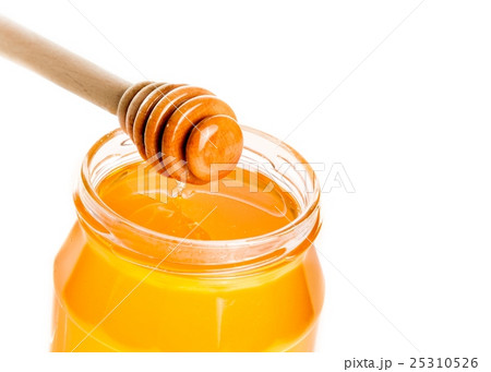 honey jar on white background with wooden honey dipper on top 25310526