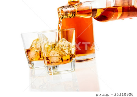 barman pouring whiskey in the glasses in front of bottle on white background with reflection 25310906