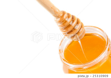 honey jar on white background with wooden honey dipper on top and drop honey honey jar on white background with wooden honey dipper on top and drop honey 25310909