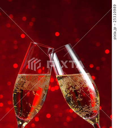 two champagne flutes on red light bokeh background 25310989