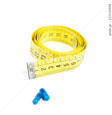 medical blue pills in front of measure tape, concept for diet 25310999